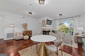 dining space with ornamental molding, a fireplace, and wood finished floors