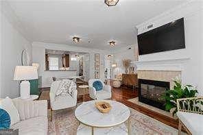 living room with a tile fireplace and wood finished floors