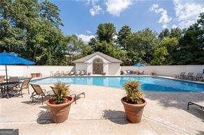 pool featuring an outbuilding, fence, and a patio area