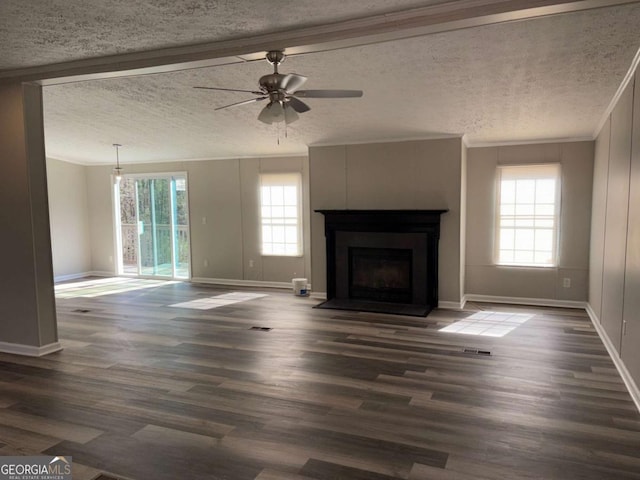 unfurnished living room featuring dark wood-style flooring, a textured ceiling, a fireplace with flush hearth, and ornamental molding