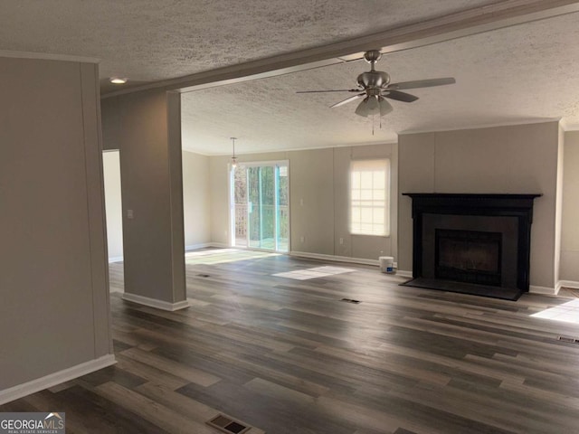 unfurnished living room with a ceiling fan, dark wood-style floors, visible vents, a fireplace, and crown molding