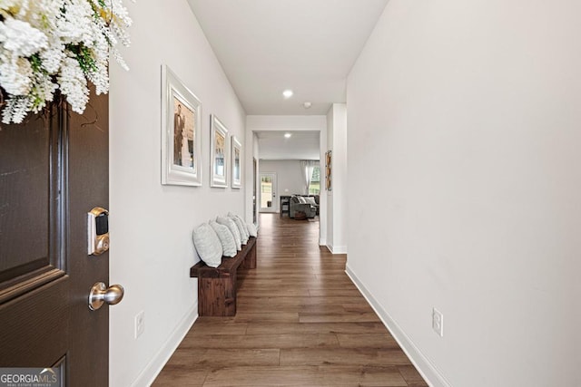 corridor featuring wood finished floors, baseboards, and recessed lighting