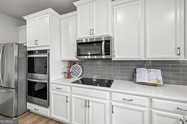119 Peachwood Ln, Homer, GA 30547 - kitchen featuring stainless steel appliances, white cabinetry, light countertops, and decorative backsplash