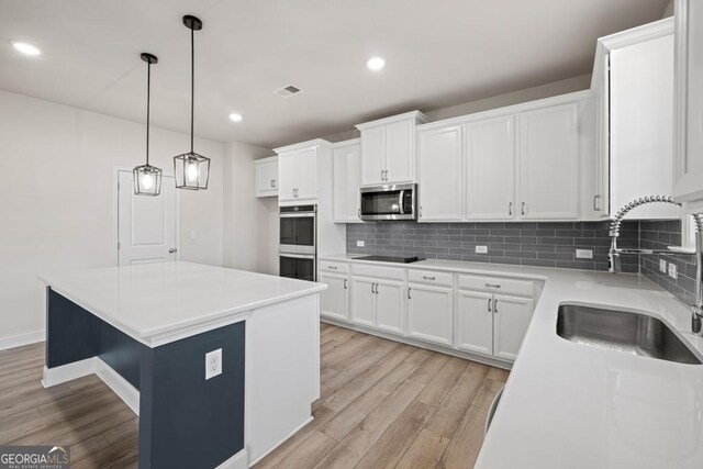119 Peachwood Ln, Homer, GA 30547 - kitchen featuring appliances with stainless steel finishes, a sink, light wood-style floors, backsplash, and recessed lighting
