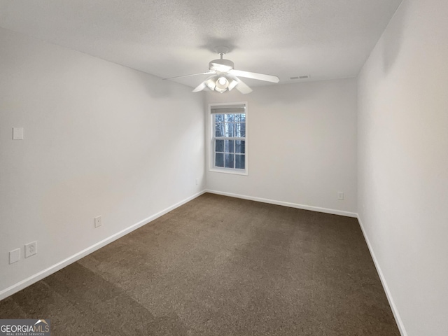 unfurnished room with baseboards, visible vents, ceiling fan, a textured ceiling, and dark colored carpet