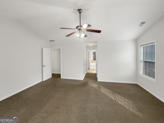 unfurnished room featuring carpet, visible vents, baseboards, ceiling fan, and vaulted ceiling