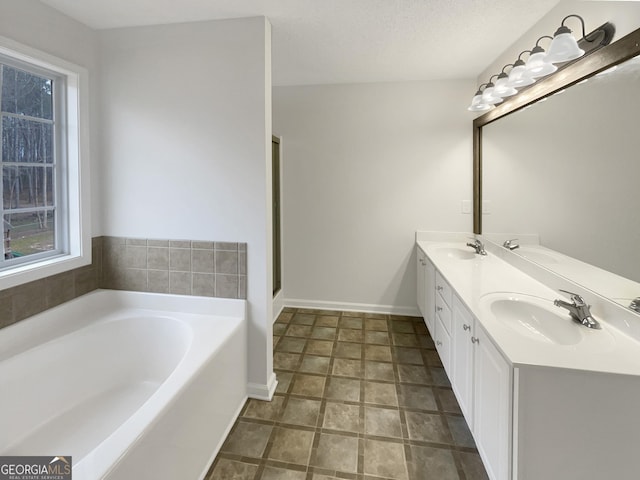 bathroom featuring a sink, a garden tub, and double vanity
