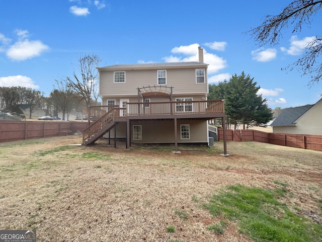 back of house with a wooden deck, stairway, a chimney, and a fenced backyard