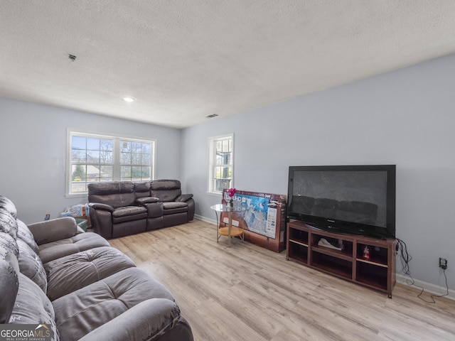 living room featuring wood finished floors, baseboards, and a textured ceiling