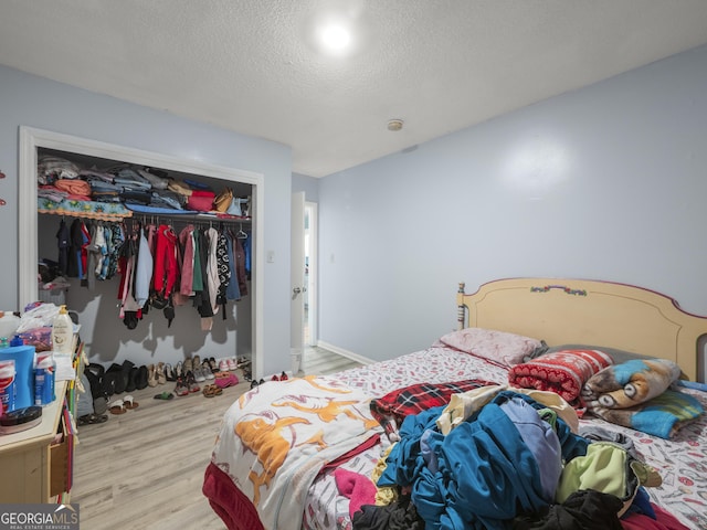 bedroom with wood finished floors, a closet, and a textured ceiling