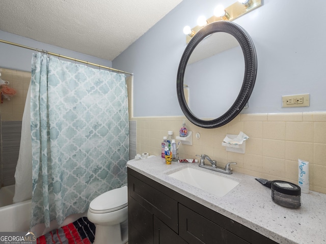 full bathroom featuring a wainscoted wall, toilet, vanity, shower / bath combo, and a textured ceiling