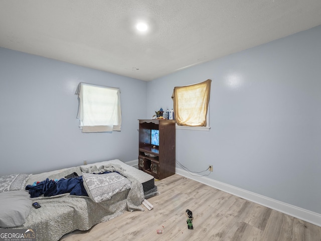 bedroom featuring baseboards and light wood-style floors