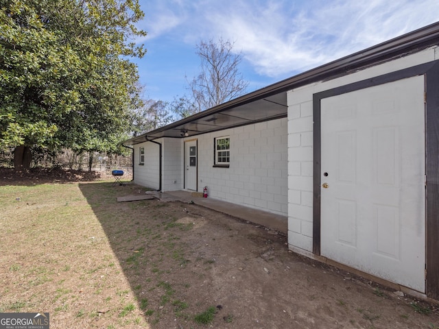 exterior space with a lawn and concrete block siding