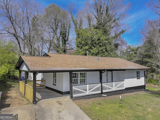 view of front of property featuring an attached carport, a shingled roof, a front lawn, a porch, and driveway