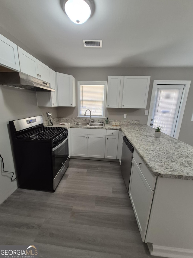 130 Royal Ct, Athens, GA 30601 - kitchen with stainless steel appliances, under cabinet range hood, a peninsula, white cabinetry, and light stone countertops