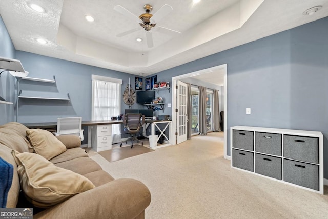 office featuring a ceiling fan, a tray ceiling, recessed lighting, carpet, and baseboards