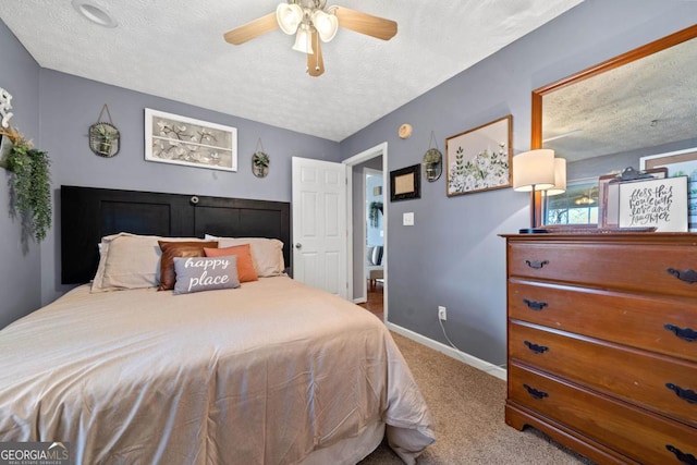 carpeted bedroom with a textured ceiling, baseboards, and a ceiling fan