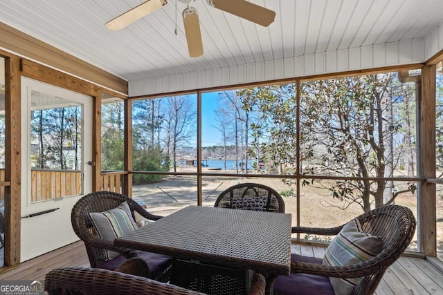 sunroom / solarium with a water view and ceiling fan
