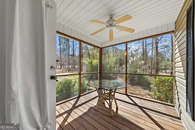 unfurnished sunroom featuring ceiling fan and outdoor dining space