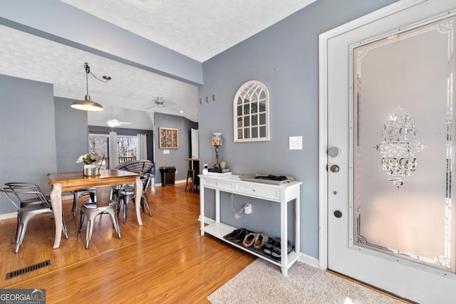 dining area with light wood-type flooring, baseboards, and visible vents
