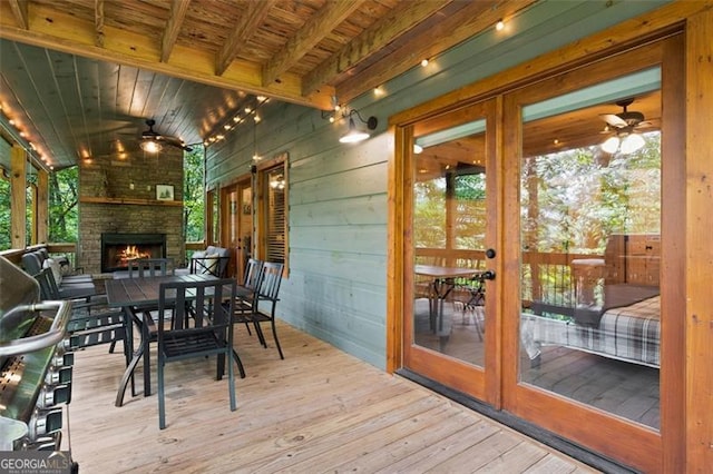 exterior space featuring outdoor dining area, french doors, an outdoor stone fireplace, and ceiling fan