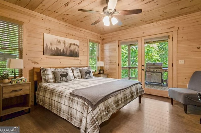bedroom featuring wood walls, access to outside, and wood finished floors