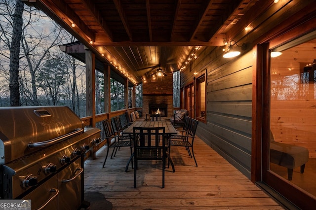 wooden terrace featuring a fireplace and a grill