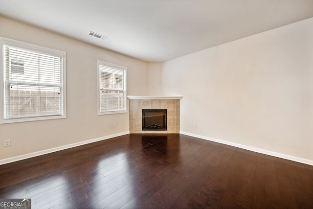 249 Madison Ave, Acworth, GA 30102 - unfurnished living room featuring baseboards, a tile fireplace, visible vents, and dark wood-style floors