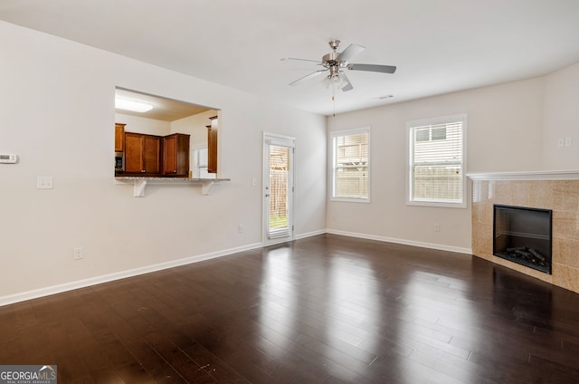 249 Madison Ave, Acworth, GA 30102 - unfurnished living room with ceiling fan, baseboards, dark wood-style flooring, and a tiled fireplace