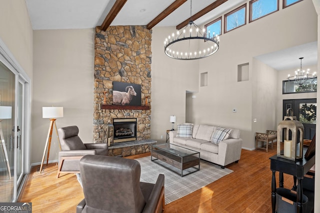 1190 Plantation Dr, Villa Rica, GA 30180 - living area featuring beamed ceiling, wood finished floors, a towering ceiling, a stone fireplace, and a chandelier