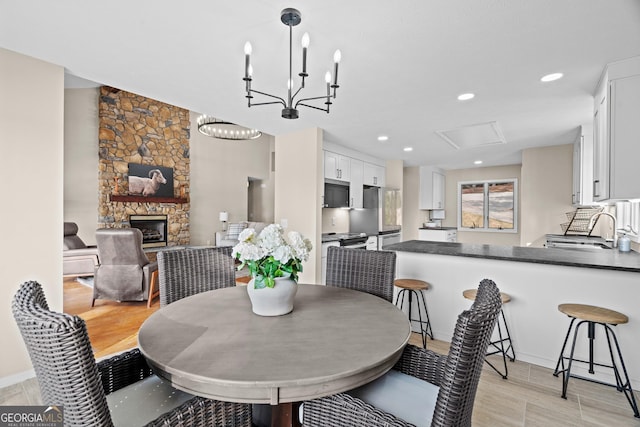 1190 Plantation Dr, Villa Rica, GA 30180 - dining area featuring a notable chandelier, recessed lighting, light wood-style flooring, and a fireplace