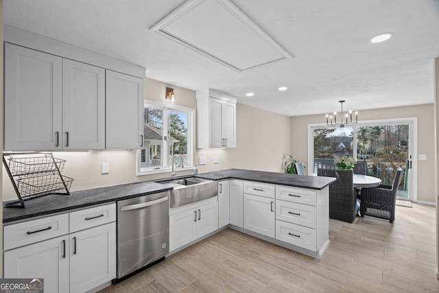 1190 Plantation Dr, Villa Rica, GA 30180 - kitchen with a sink, dark countertops, stainless steel dishwasher, a peninsula, and white cabinets