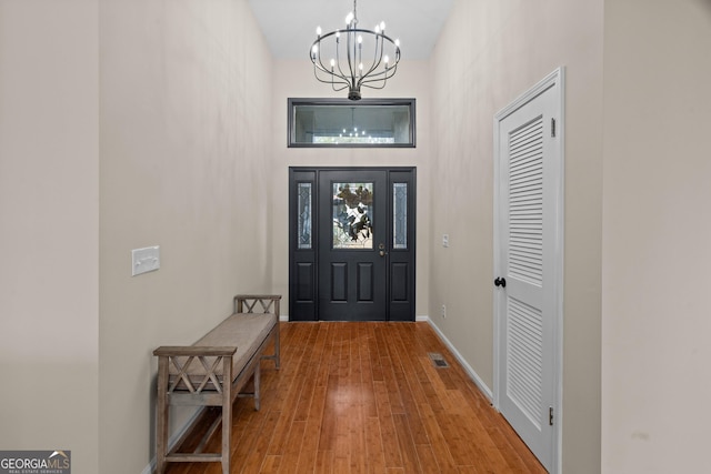 1190 Plantation Dr, Villa Rica, GA 30180 - foyer entrance with a notable chandelier, wood finished floors, visible vents, and baseboards