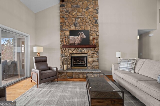 1190 Plantation Dr, Villa Rica, GA 30180 - living area featuring a stone fireplace, high vaulted ceiling, baseboards, and wood finished floors