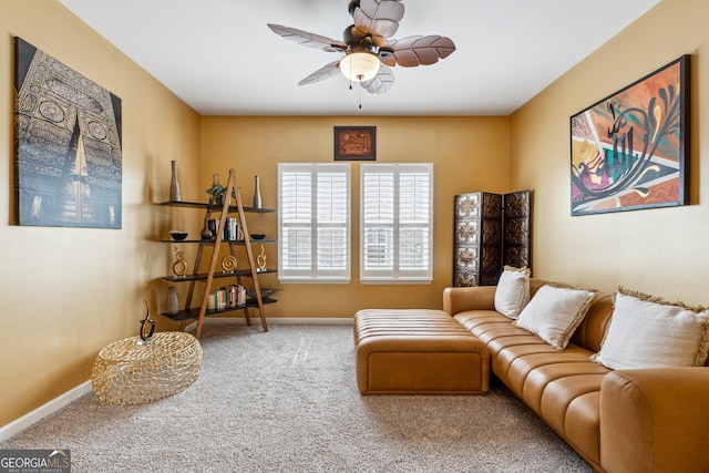living area featuring baseboards, carpet, and a ceiling fan