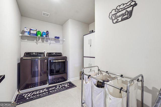laundry room with light tile patterned floors, visible vents, independent washer and dryer, and baseboards