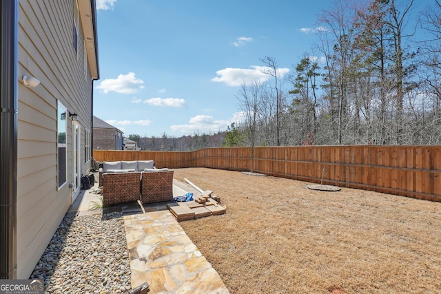 view of yard with a patio area, an outdoor living space, and a fenced backyard