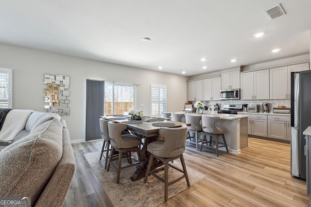 dining room with recessed lighting, light wood-style floors, and visible vents