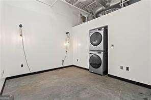 washroom featuring baseboards and stacked washer and clothes dryer