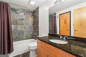 bathroom featuring vanity, toilet, and shower / tub combo