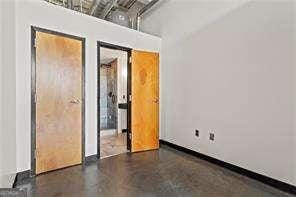 unfurnished bedroom featuring finished concrete floors