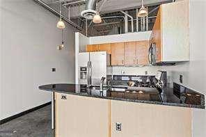 kitchen featuring dark countertops, a peninsula, and stainless steel fridge with ice dispenser