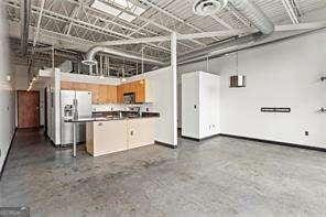 garage featuring refrigerator with ice dispenser and baseboards