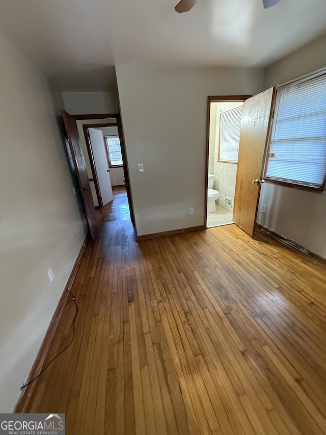 spare room with baseboards, ceiling fan, and hardwood / wood-style flooring