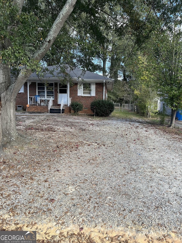view of front facade featuring brick siding and a porch