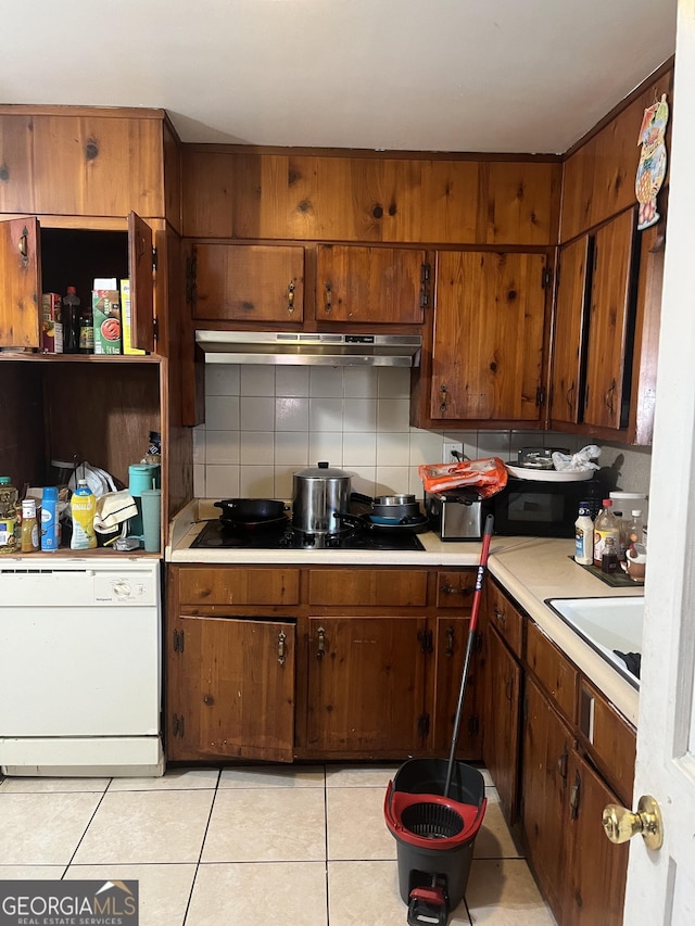 kitchen featuring black electric stovetop, under cabinet range hood, dishwasher, light countertops, and decorative backsplash
