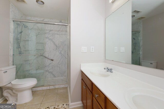 full bathroom with visible vents, toilet, a sink, a marble finish shower, and double vanity