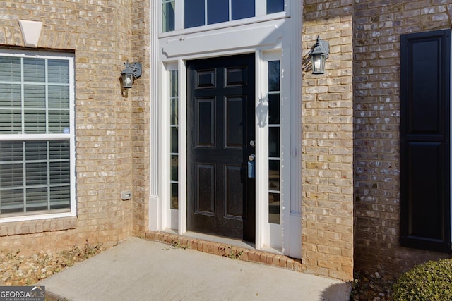 view of exterior entry with brick siding
