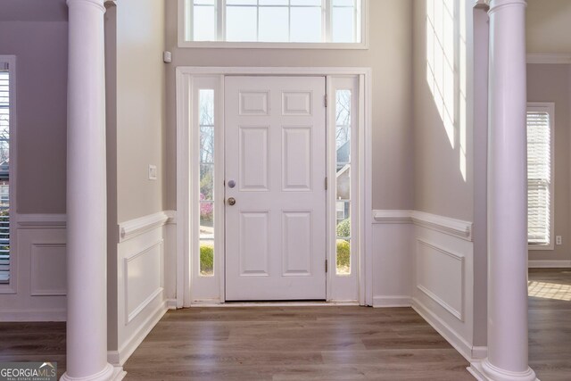 entryway featuring a decorative wall, a wainscoted wall, and wood finished floors
