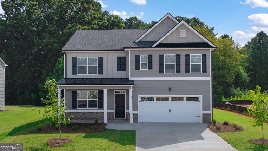 646 Daurian Dr, Statham, GA 30666 - craftsman-style house with board and batten siding, concrete driveway, a front yard, roof with shingles, and a garage